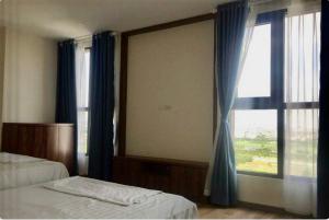 ein Schlafzimmer mit zwei Betten und einem großen Fenster in der Unterkunft Northern Diamond Golfstay in Hanoi + 4 Fotos