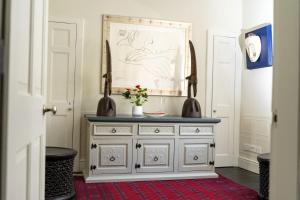 a room with a dresser with a painting on the wall at Bespoke Central Town House in Bath +26 photos