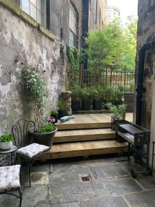 a patio with a bench and a piano next to a building at Bespoke Central Town House in Bath