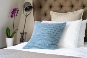 a bed with a blue and white pillow on it at Bespoke Central Town House in Bath