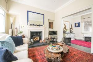 a living room with a couch and a fireplace at Bespoke Central Town House in Bath
