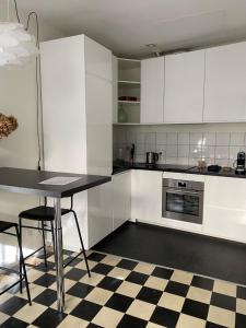a kitchen with white cabinets and a checkered floor at Dépendance calme avec jardin au coeur de Bordeaux in Bordeaux +15 photos
