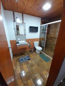 a bathroom with a toilet and a shower and a sink at Loft Campos a 12 minutos do centro turistico de Campos do Jordão in Campos do Jordão