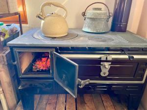 a stove with a tea kettle on top of it at Guesthouse RAMAJ in Perondi