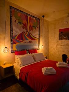 Un dormitorio con una cama roja con una pintura en la pared en CLALE ROOMS, en Nápoles