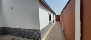 an empty hallway of a building with a window at BTourays Rentals in Yundum +7 photos