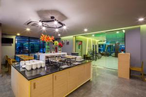 a restaurant with a counter with white dishes on it at Livotel Hotel Kaset Nawamin Bangkok in Bangkok
