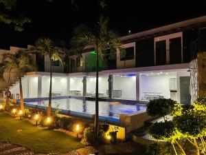 a swimming pool in front of a building at night at Caloocan Private Resort in Manila