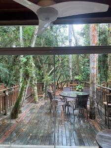 サンセバスチャンにあるCasa em Juquehy com muita naturezaのウッドデッキ(テーブル、椅子付)