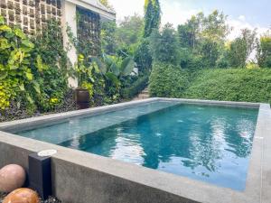 a swimming pool in the backyard of a house at Akara House Sukhothai - Luxury Riverside Residence in Sukhothai