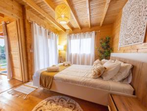 ein Schlafzimmer mit einem großen Bett in einem Holzzimmer in der Unterkunft Mountain Wood Village in Madalena