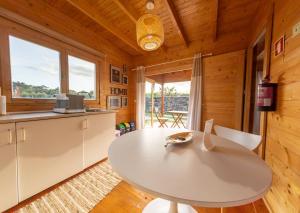 eine Küche und ein Esszimmer mit einem großen weißen Tisch in der Unterkunft Mountain Wood Village in Madalena + 35 Fotos