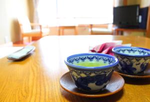 2 bols bleus et blancs assis sur une table en bois dans l'établissement Hanare Kitaoka, à Itō