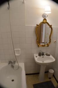 une salle de bains avec lavabo, miroir et baignoire dans l'établissement Gite du Relarguier, maison de village en Luberon, Provence, à Mérindol 30 autres photos