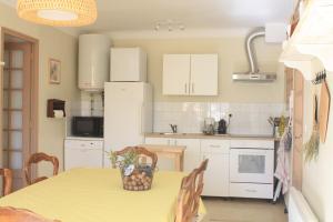 une cuisine avec une table et un chiffon de table jaune dans l'établissement Gite du Relarguier, maison de village en Luberon, Provence, à Mérindol