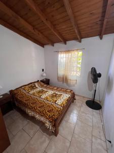 Un dormitorio con una cama en una habitación con ventana. en La frontera chalet, en Las Toninas