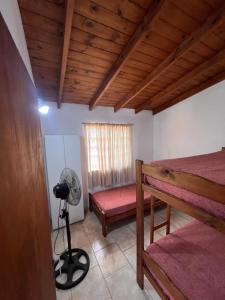 1 dormitorio con 1 cama, ventilador y ventana en La frontera chalet, en Las Toninas