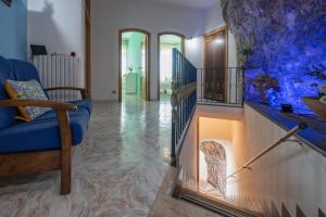 un salon avec un canapé bleu et une cheminée dans l'établissement Villa with pool and gardens with wonderful sea view, à Conca dei Marini