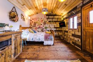 a bedroom with a bed and a wooden ceiling at The Goose lodge in Calveley