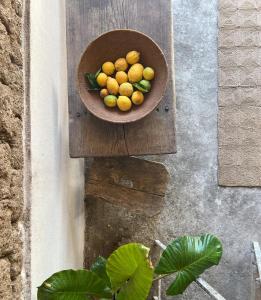 a bowl of fruit sitting on a wooden stand at Casa Manamunda in San Vero Milis