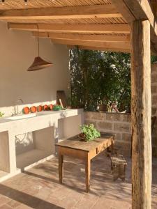 a patio with a wooden table and a kitchen at Casa Manamunda in San Vero Milis