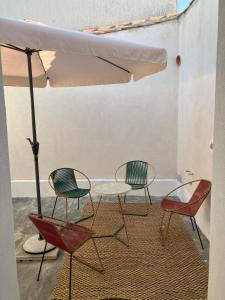three chairs and a table and an umbrella at Casa Manamunda in San Vero Milis