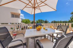 a table and chairs with an umbrella on a patio at House Santro in Baška Voda