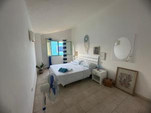 圣玛丽亚More then a beautiful apart The real Morabeza Capeverdean hospitality的卧室里有一张床，墙上有一面镜子 更多16张照片