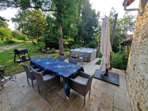 a patio with a table and chairs and an umbrella at La forge des vignes in Menetou-Râtel