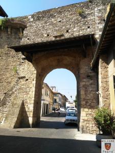 un arco in un edificio in pietra con auto parcheggiate di Casa S Trinita 15 min train station, visit Tuscany a Prato