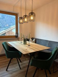 a dining room with a wooden table and green chairs at Ferienwohnungen Hell in Uderns +28 photos