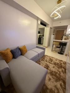 a living room with a white couch and a kitchen at Glamorous SMDC Shore 3, 5 Star Rate BnB-Wifi-Netflix in Manila