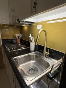 a kitchen counter with a sink and a stove at Glamorous SMDC Shore 3, 5 Star Rate BnB-Wifi-Netflix in Manila