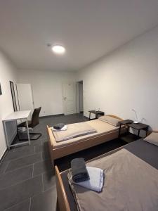 a room with two beds and a desk in it at Pension Imhof in Oyten