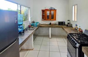 a kitchen with a sink and a stove at Nómadas Hostel in Moyogalpa