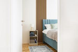 a bedroom with a blue bed and a window at HeyYou Apartment in Bjelovar