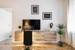 a living room with a television on a wooden dresser at HeyYou Apartment in Bjelovar