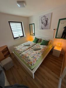 a bedroom with a large bed with green pillows at La Hiška Čatež - each guest gets 2 Thermal Riviera entries per day in Čatež ob Savi +18 photos