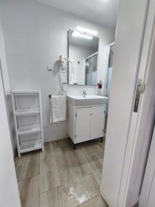 biała łazienka z umywalką i lustrem w obiekcie Apartamento Salinas w mieście Pozo Izquierdo +37 zdjęć