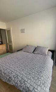 ein Schlafzimmer mit einem großen Bett mit Bettdecke und Kissen in der Unterkunft Studio plein centre, calme, parking inclus, piscine et gardien in Grenoble