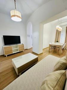 Una sala de estar con un sofá y un televisor de pantalla plana. en Apartamento Rei Center, en Mérida