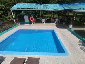 Una gran piscina azul con un cenador en Casa Mar, en Quepos