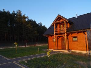 a wooden cabin with a porch on the side of a road at EkoZagroda in Skrzyneczki