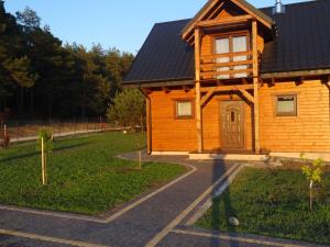 a wooden house with a black roof at EkoZagroda in Skrzyneczki +11 photos