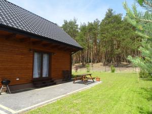 a wooden cabin with a picnic table in the yard at EkoZagroda in Skrzyneczki