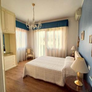 Un dormitorio con una cama grande y una lámpara de araña. en Villa Elza, en Forte dei Marmi