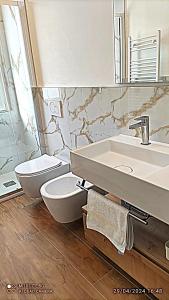 Un baño con lavabo, inodoro y espejo. en Villa Elza, en Forte dei Marmi 36 fotos más