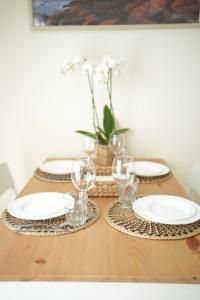 a wooden table with plates and wine glasses on it at Cute apart with the garden in Turin