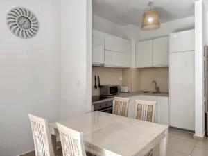 a kitchen with white cabinets and a table and chairs at Lavender Bay D04 in Donji Morinj