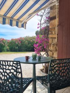 einen Tisch und zwei Stühle auf einer Terrasse in der Unterkunft Studio cosy à 200m de la plage Parking & Wi-Fi in Bormes-les-Mimosas